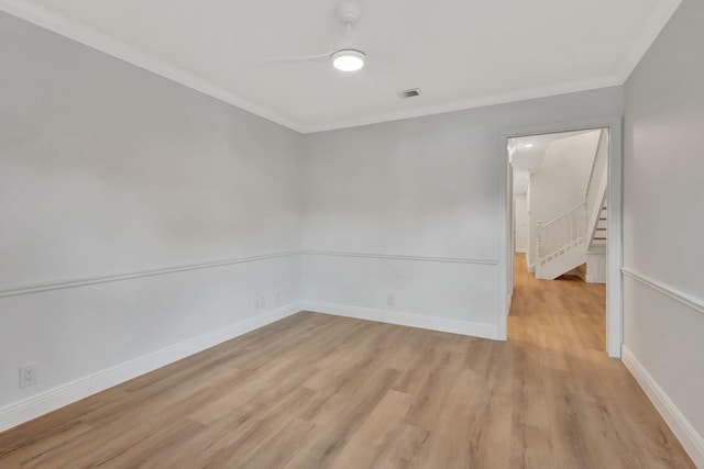 empty room with light hardwood / wood-style flooring and crown molding