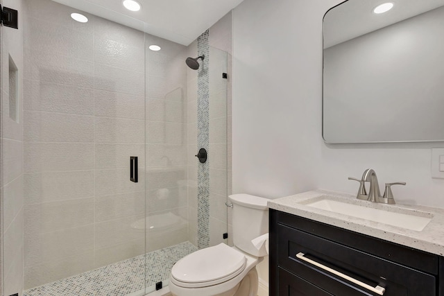 bathroom featuring vanity, toilet, and a shower with door