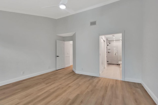 unfurnished bedroom with ceiling fan, light wood-type flooring, and ensuite bath