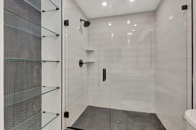 bathroom with toilet and a shower with shower door