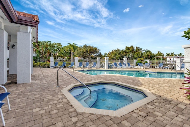 view of swimming pool featuring a community hot tub and a patio