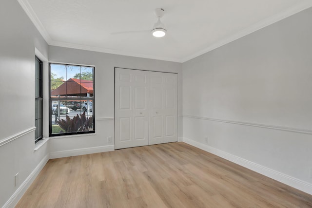 unfurnished bedroom featuring light wood-type flooring, a closet, ceiling fan, and ornamental molding