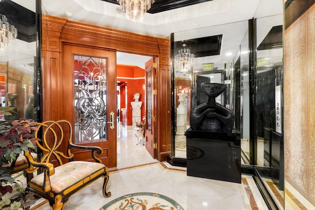 entryway with a chandelier, crown molding, and a tray ceiling