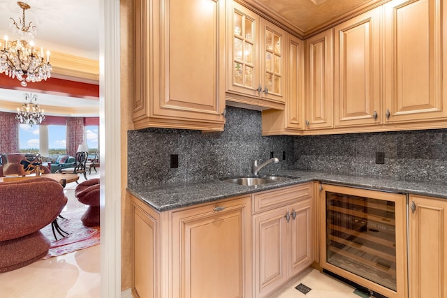 kitchen with dark stone countertops, hanging light fixtures, beverage cooler, and sink