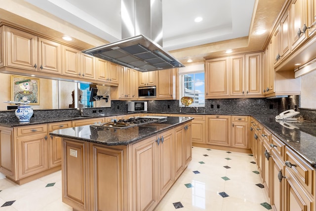 kitchen with a center island, island range hood, stainless steel appliances, and dark stone counters