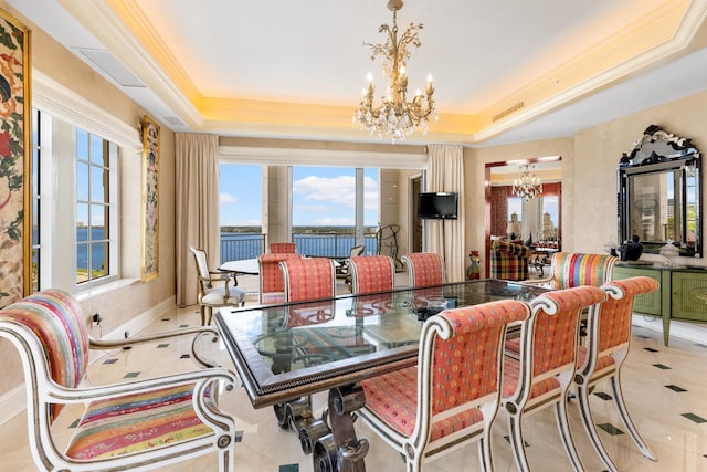 dining room featuring an inviting chandelier, light tile patterned floors, crown molding, and a tray ceiling