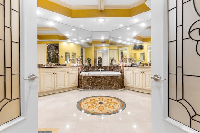 bathroom with vanity, a relaxing tiled tub, and crown molding