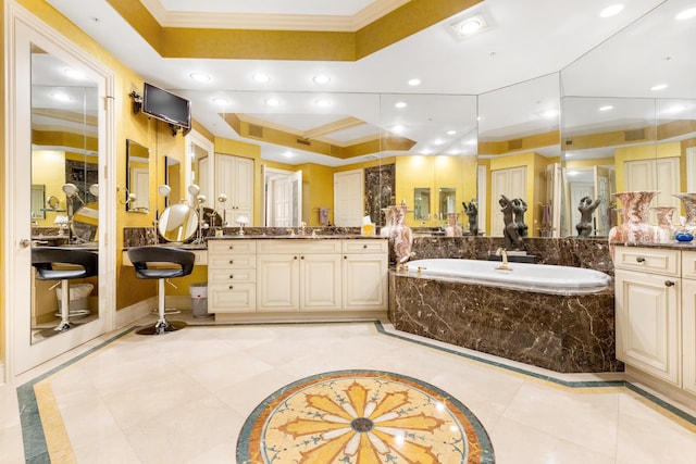 bathroom featuring a tray ceiling, tiled bath, crown molding, and vanity