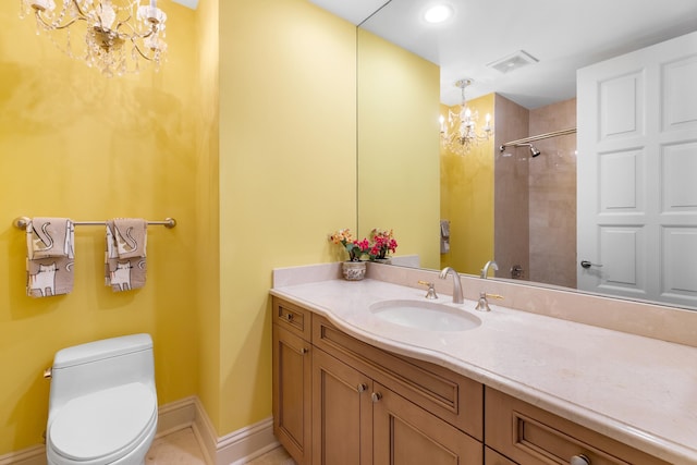 bathroom featuring tile patterned floors, vanity, a chandelier, and toilet