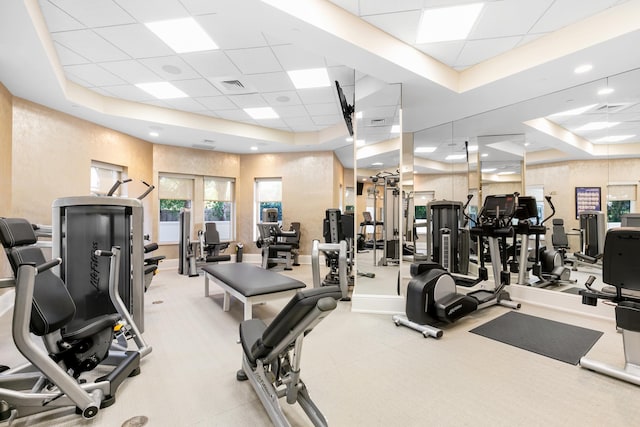 workout area with a paneled ceiling and a raised ceiling