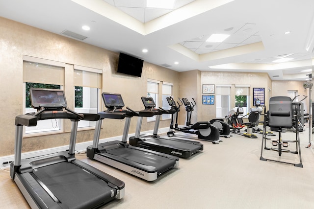 workout area with light carpet and a tray ceiling