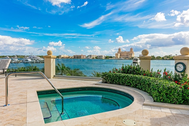 view of pool with an in ground hot tub and a water view