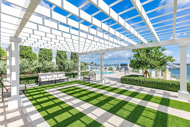 view of patio with a water view, a pergola, and a community pool