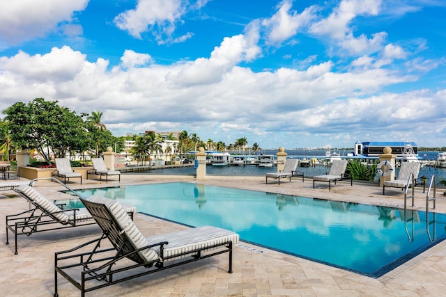 view of swimming pool with a water view and a patio