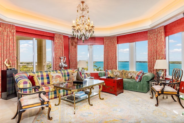 living room featuring a water view, an inviting chandelier, a wealth of natural light, and a tray ceiling