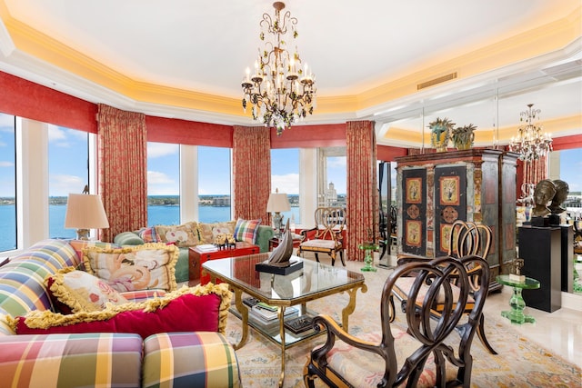 living room with a tray ceiling, a water view, a chandelier, and ornamental molding