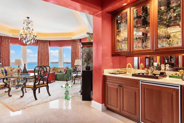 bar featuring decorative light fixtures, a water view, a chandelier, and a tray ceiling