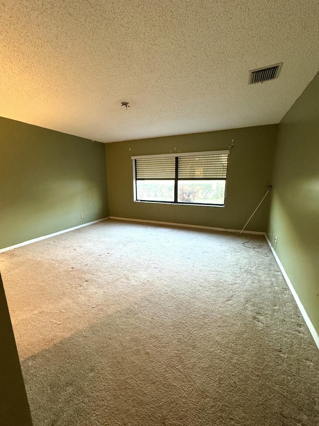 empty room featuring carpet floors and a textured ceiling