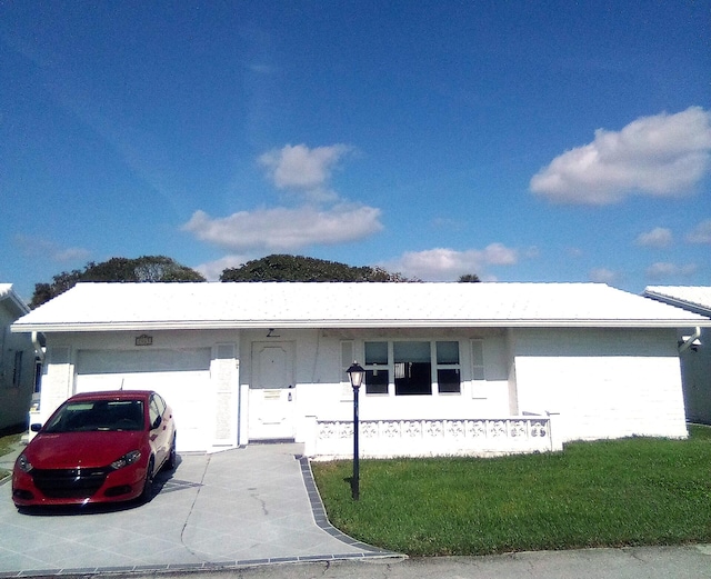 ranch-style home featuring an attached garage, driveway, and a front yard