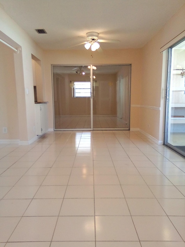 spare room featuring visible vents, ceiling fan, baseboards, and light tile patterned floors