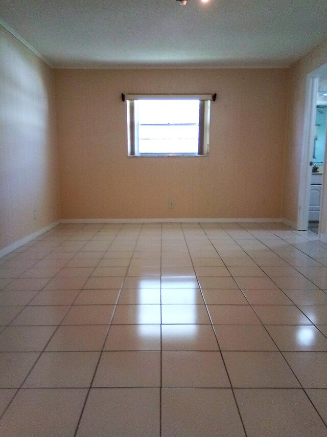 unfurnished room with baseboards and light tile patterned floors