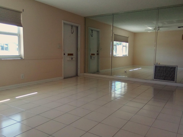 tiled spare room featuring ceiling fan