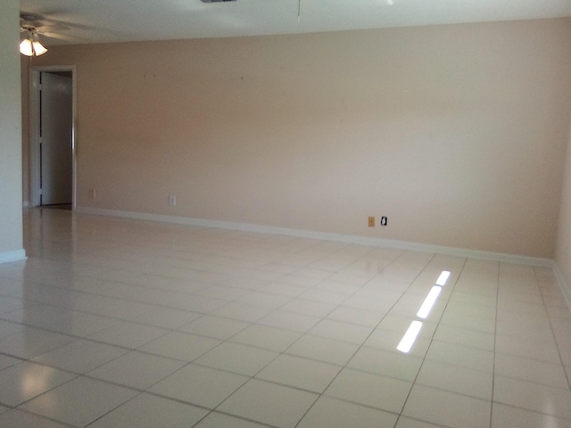 spare room with ceiling fan and light tile patterned flooring