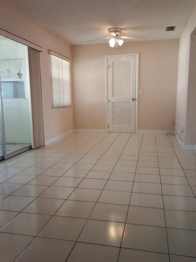 unfurnished room with ceiling fan and light tile patterned floors