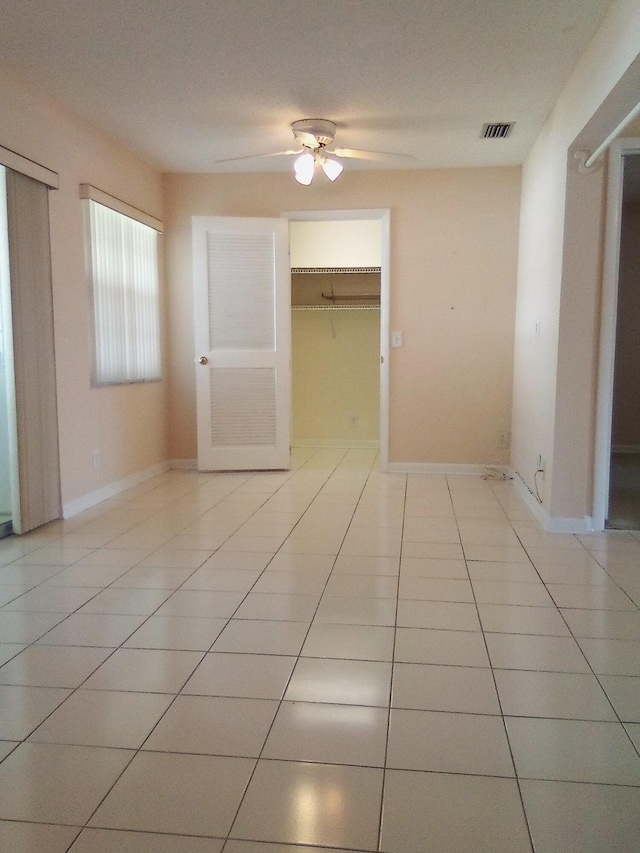 tiled spare room with ceiling fan