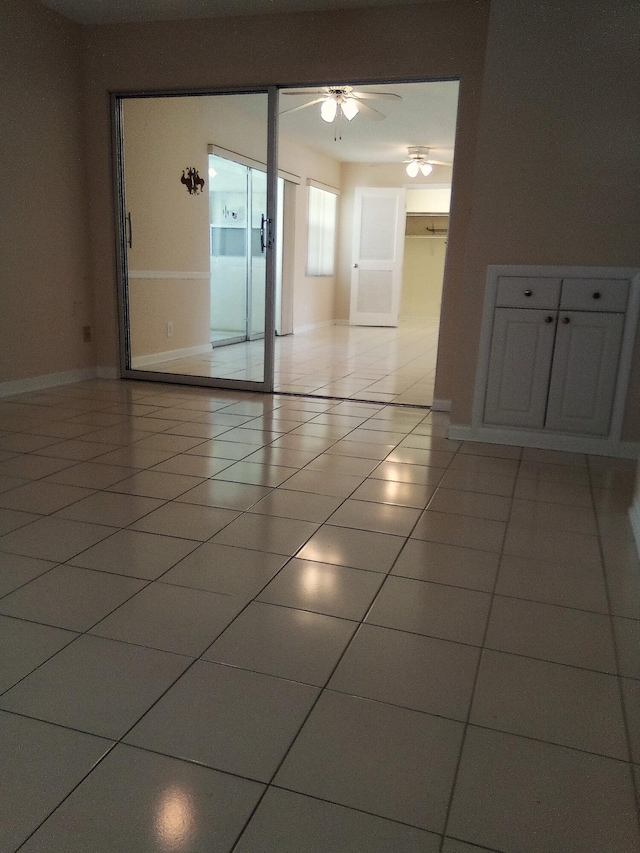 tiled empty room featuring ceiling fan