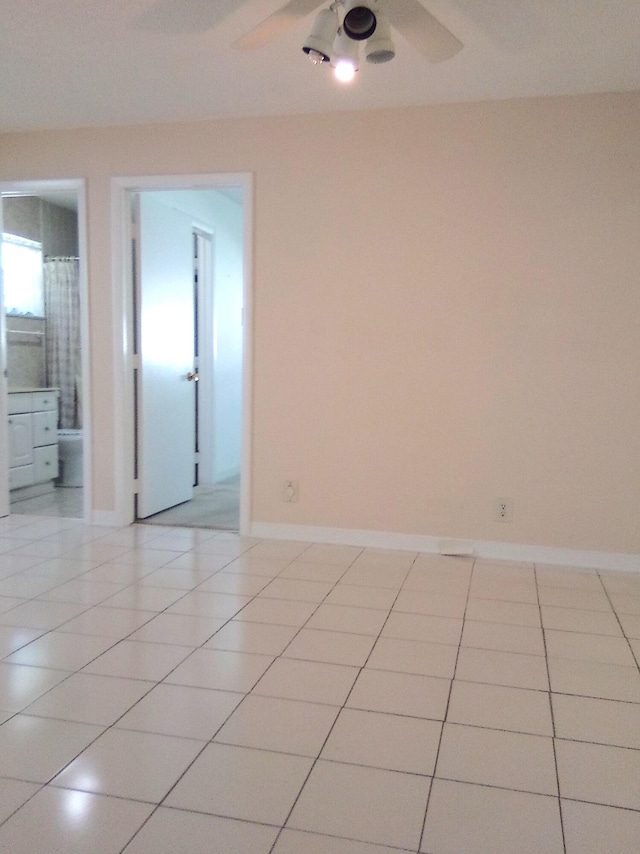 tiled empty room featuring ceiling fan