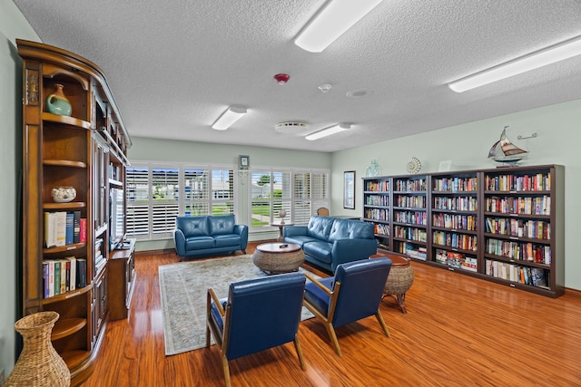 sitting room featuring a textured ceiling and wood finished floors