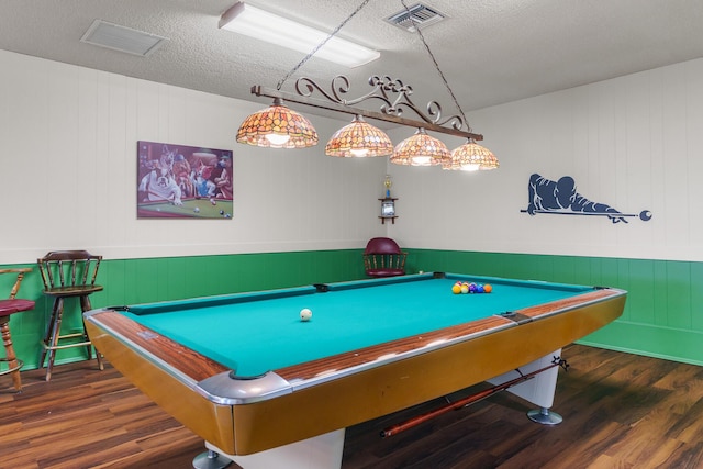 game room with a textured ceiling, visible vents, and wood finished floors