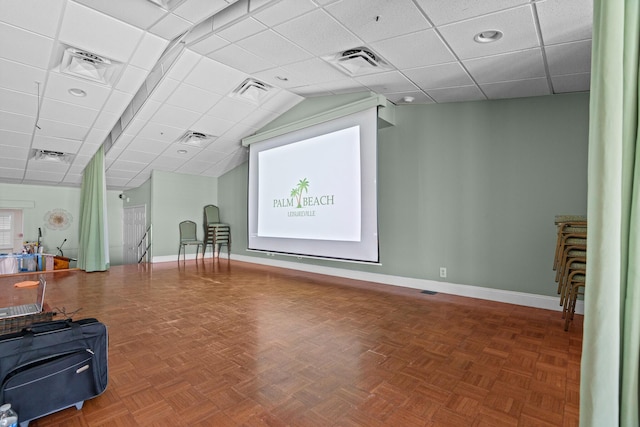 exercise area featuring a paneled ceiling and parquet floors