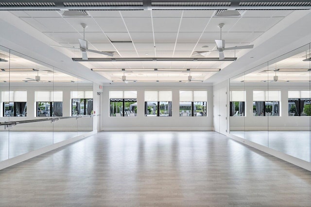 interior space featuring a paneled ceiling, light hardwood / wood-style flooring, and ceiling fan