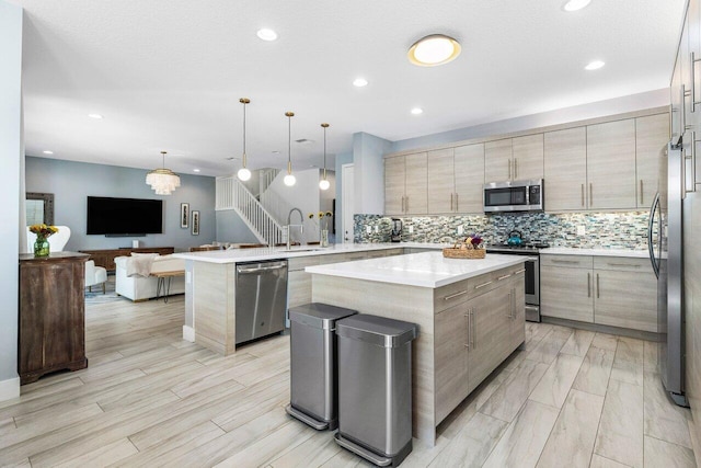 kitchen featuring sink, a center island, pendant lighting, and appliances with stainless steel finishes