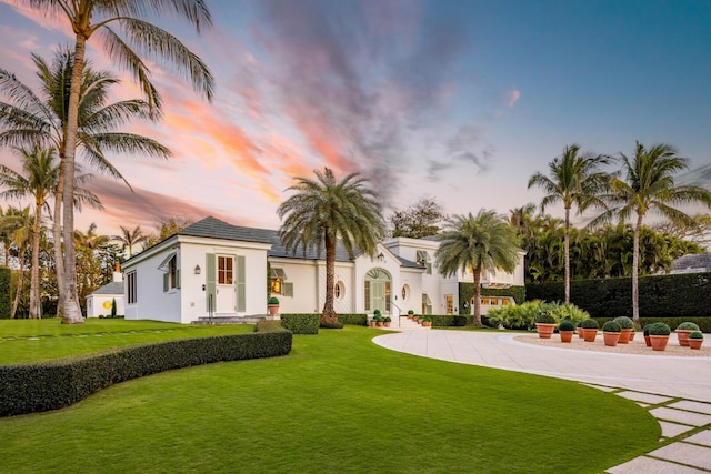 view of front of house with a lawn and stucco siding