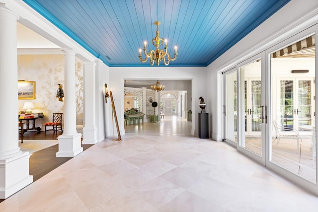 corridor with french doors, decorative columns, wood ceiling, crown molding, and a chandelier