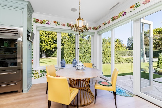 sunroom / solarium featuring a chandelier