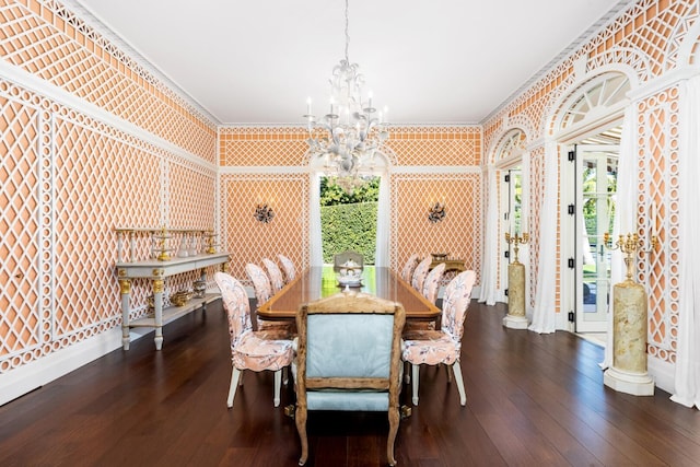 dining room featuring crown molding, dark wood-type flooring, and an inviting chandelier