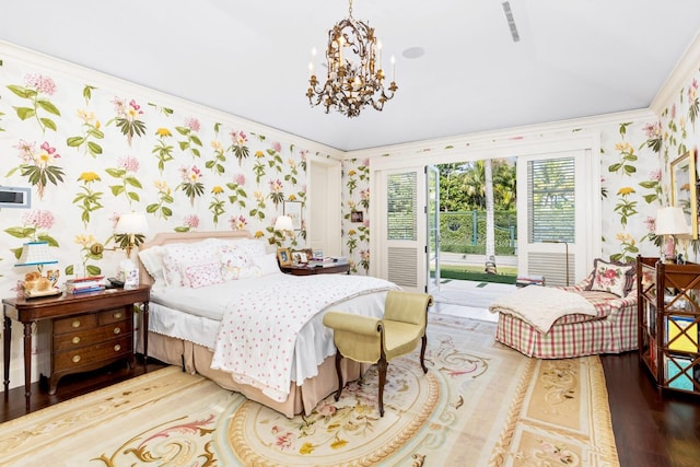 bedroom featuring access to exterior, wood-type flooring, an inviting chandelier, and ornamental molding