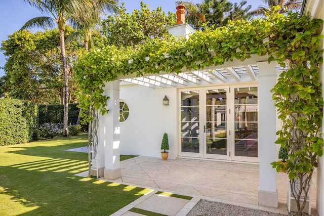 view of outdoor structure featuring a yard and french doors