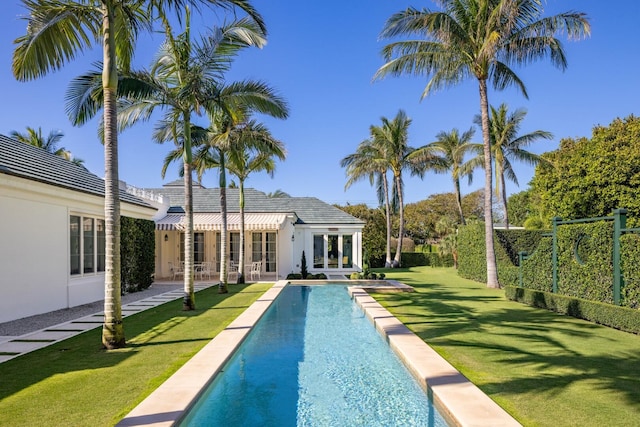 view of pool with a lawn and french doors