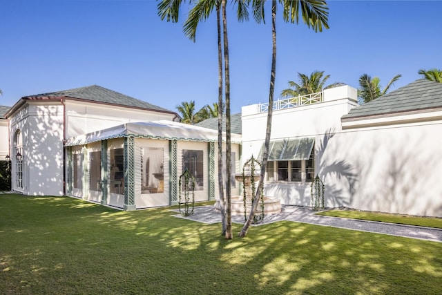 back of house featuring a lawn and a patio area