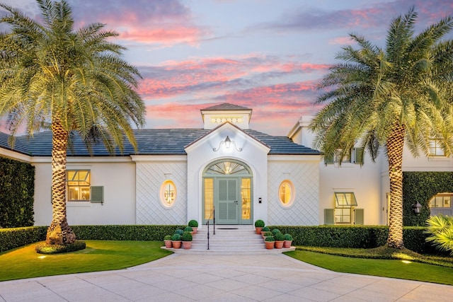 view of front of property featuring a lawn and french doors