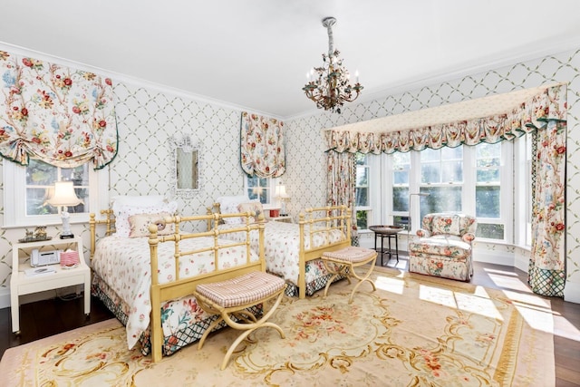 bedroom with hardwood / wood-style flooring, crown molding, and a chandelier