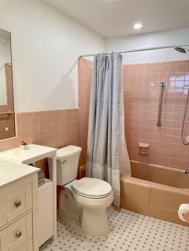 full bathroom featuring tile patterned flooring, shower / bath combination with curtain, toilet, vanity, and tile walls