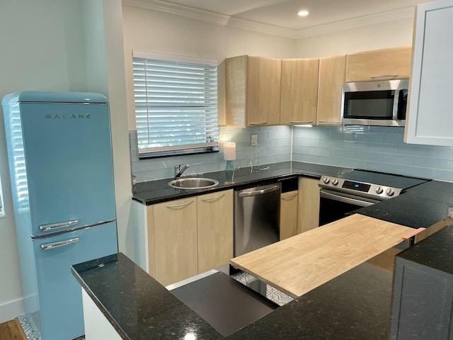 kitchen featuring tasteful backsplash, dark stone countertops, sink, and appliances with stainless steel finishes