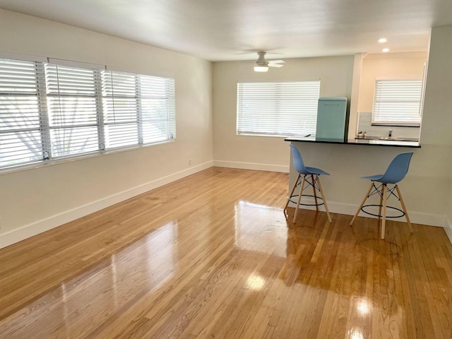 unfurnished dining area with ceiling fan and light hardwood / wood-style floors