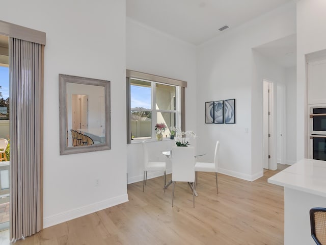 dining area featuring light hardwood / wood-style floors and ornamental molding